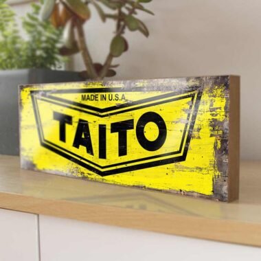 Taito Retro Game Sign. This sign brings the iconic logo of one of the most influential arcade game companies to life. Perfect for any gaming enthusiast, this piece adds a nostalgic touch to any room.